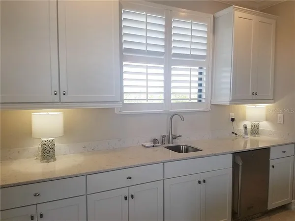 a kitchen with stainless steel appliances white cabinets and a window