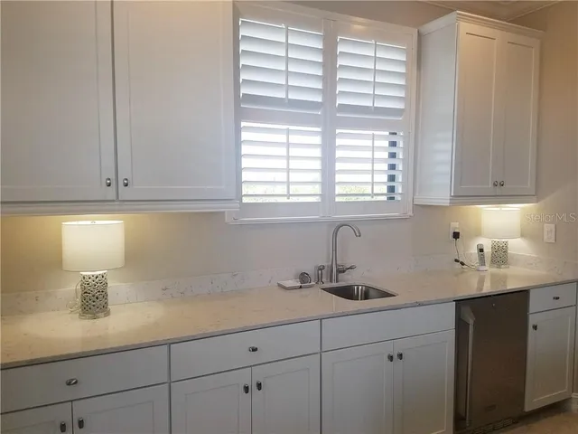 a kitchen with stainless steel appliances white cabinets and a window