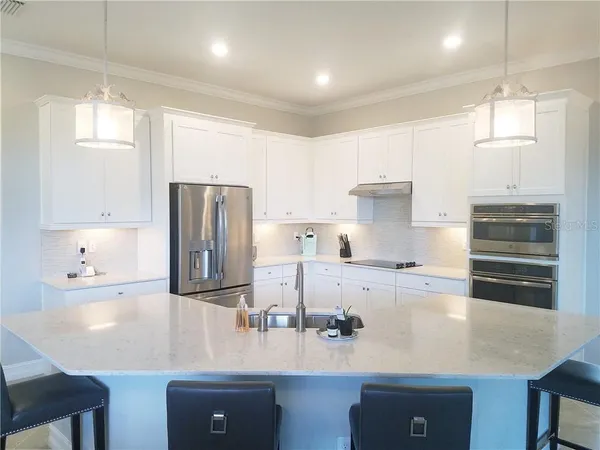 a kitchen with kitchen island a sink stove and refrigerator