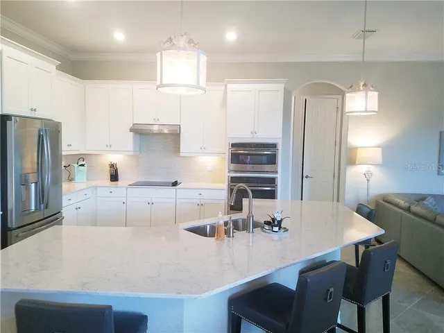 a kitchen with a dining table chairs and refrigerator