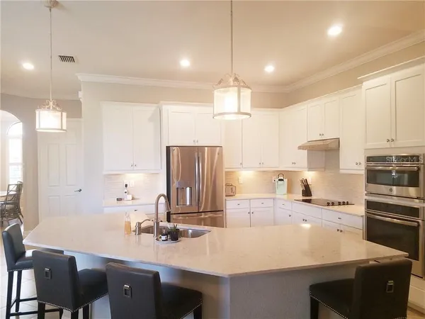 a kitchen with kitchen island a sink stove and refrigerator