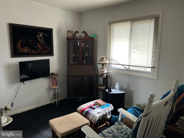 a living room with furniture and a painting on the wall