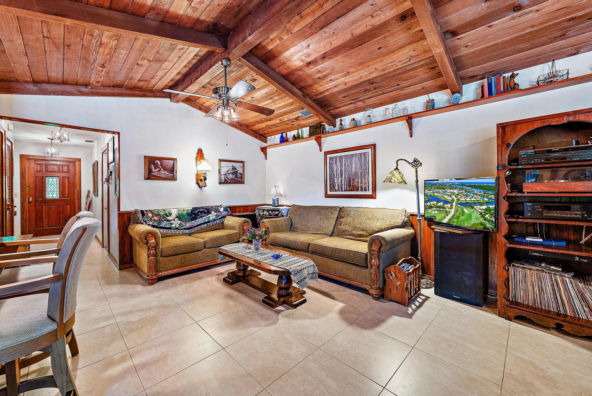 16800 128th Trail North Jupiter, FL 33478 - Photo 15 of 52 a living room with furniture a flat screen tv and a book shelf
