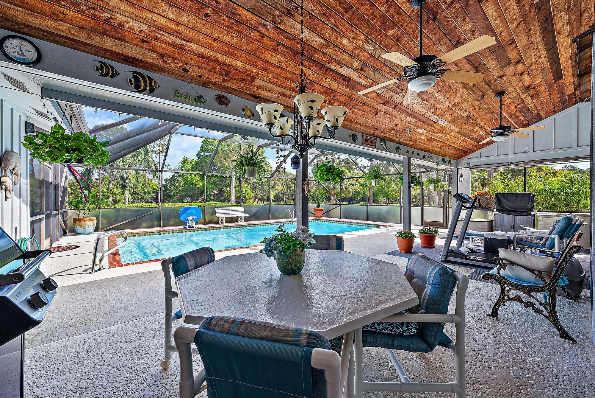 16800 128th Trail North Jupiter, FL 33478 - Photo 24 of 52 a view of a patio with a table chairs and a backyard
