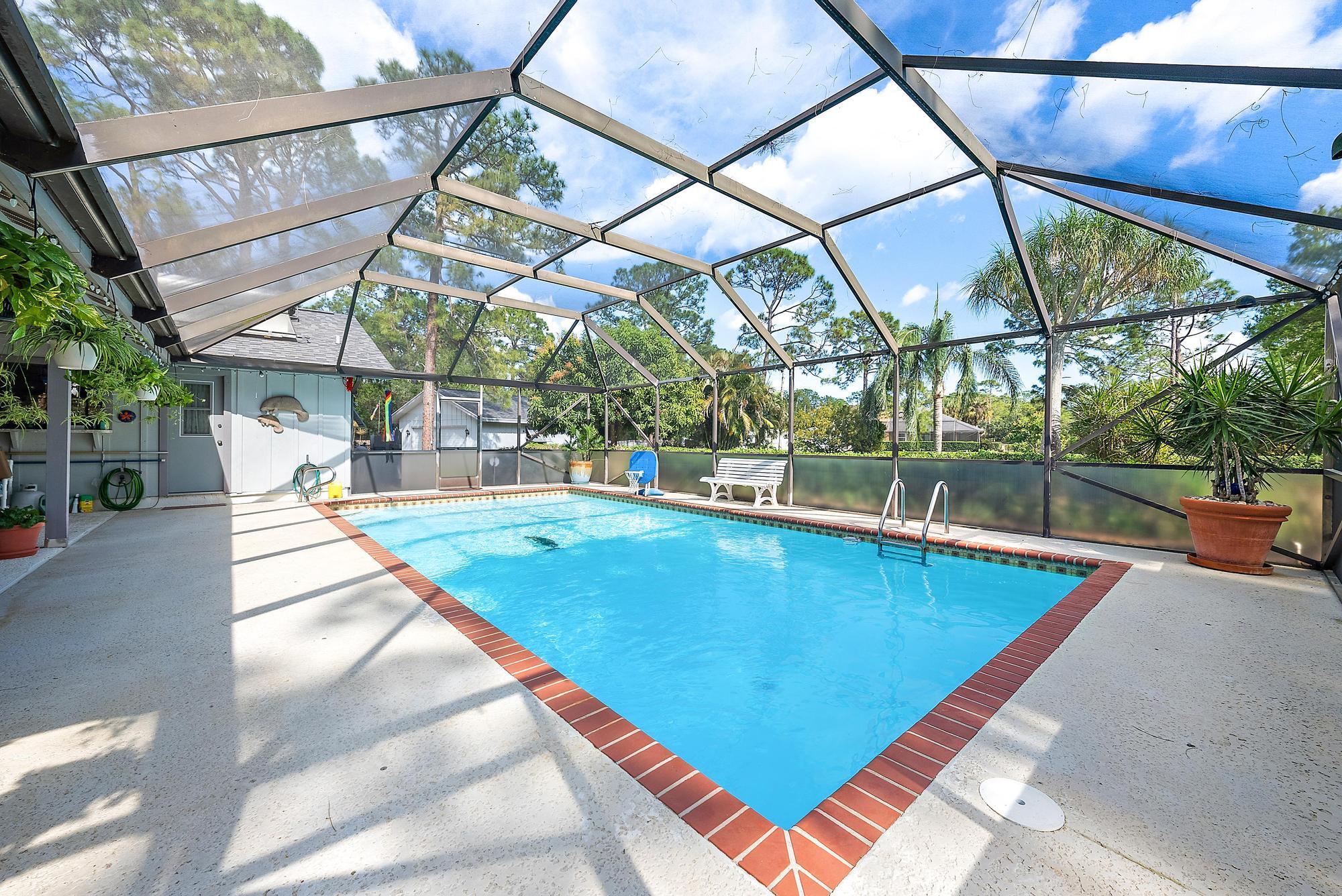 16800 128th Trail North Jupiter, FL 33478 - Photo 27 of 52 a view of a swimming pool with a patio and a yard