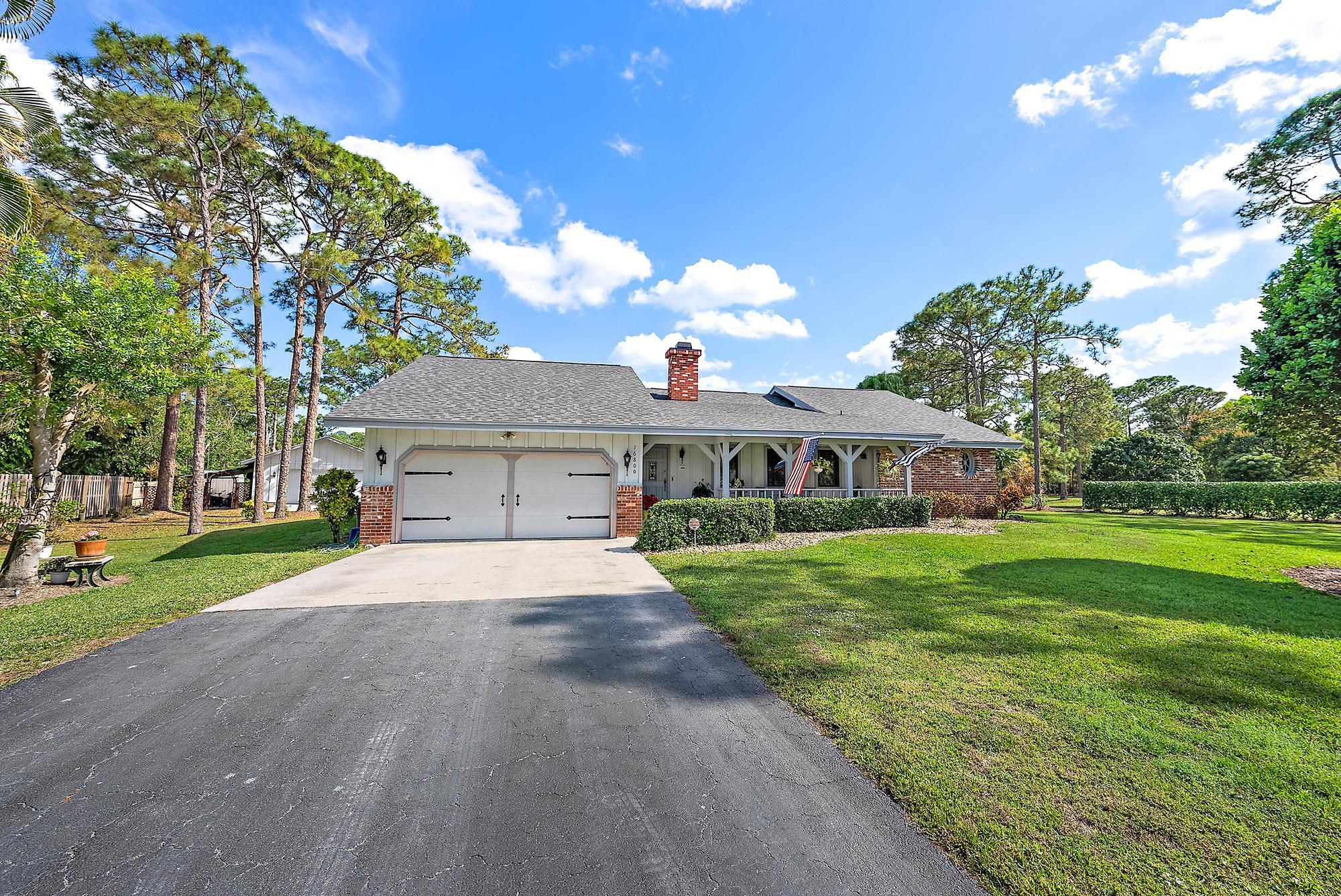 16800 128th Trail North Jupiter, FL 33478 - Photo 28 of 52 a front view of a house with a yard and garage