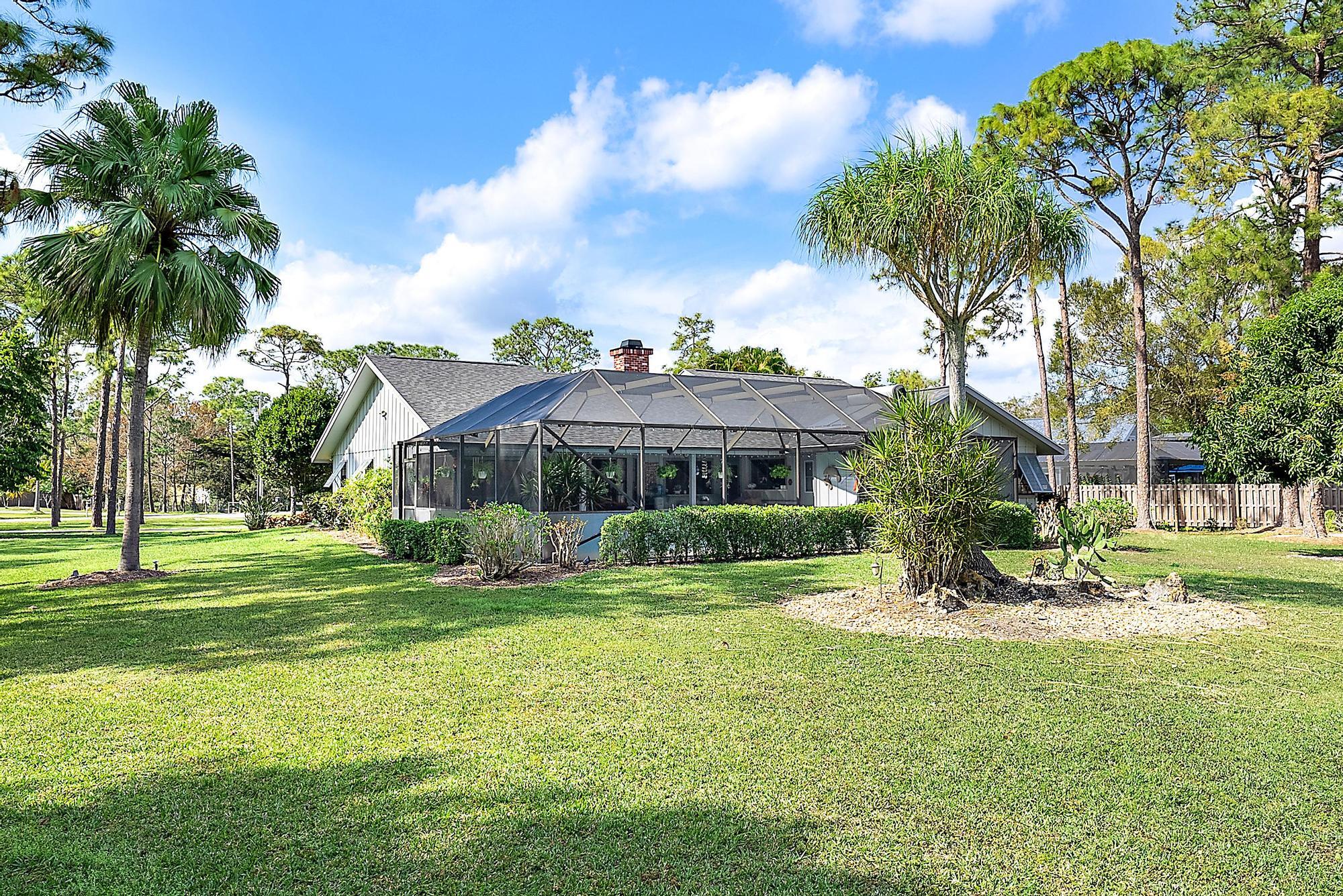 16800 128th Trail North Jupiter, FL 33478 - Photo 33 of 52 a view of a house with a big yard and palm trees