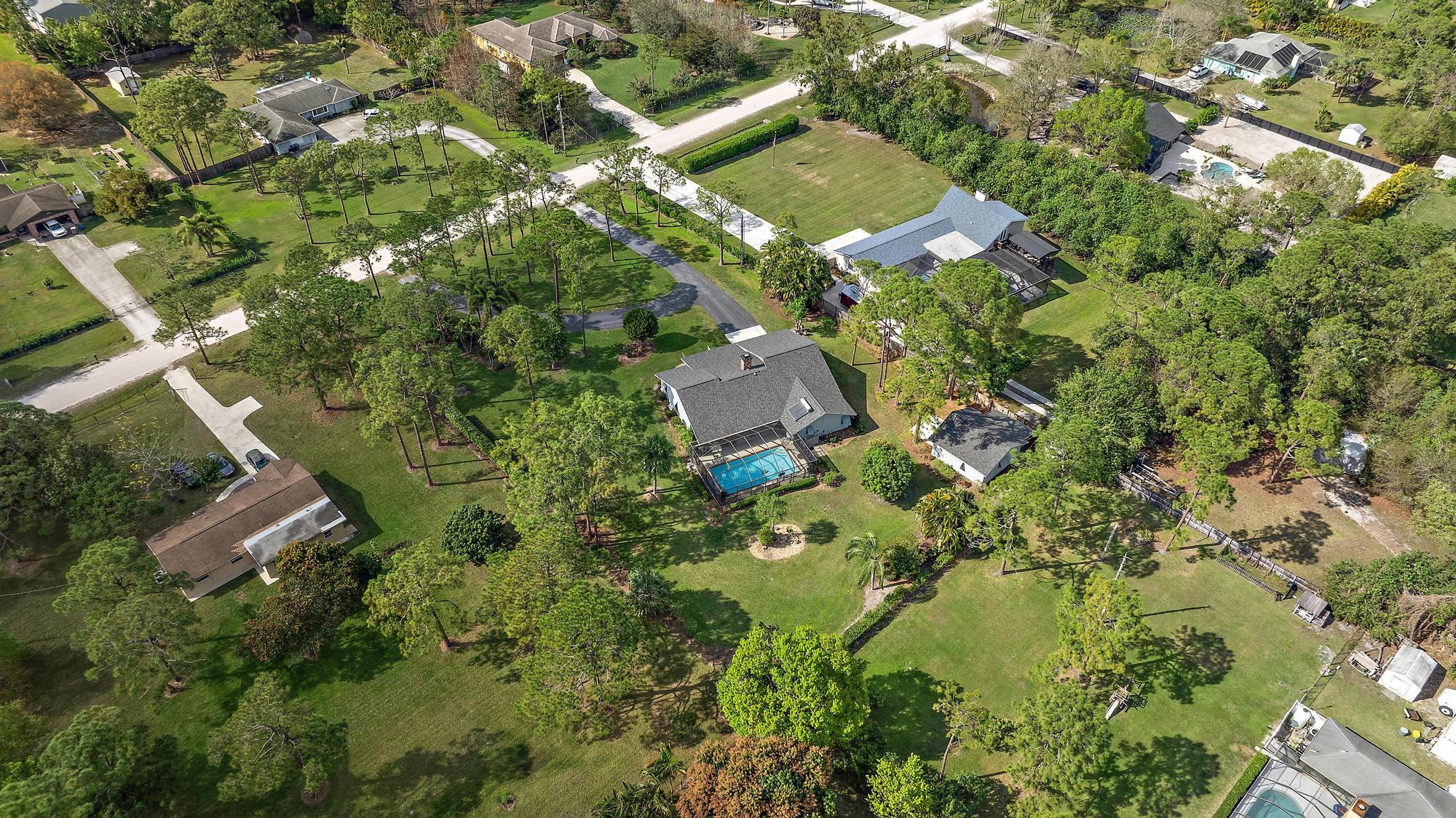 16800 128th Trail North Jupiter, FL 33478 - Photo 44 of 52 an aerial view of residential houses with outdoor space and trees