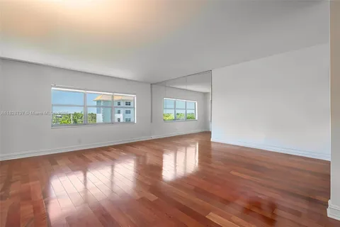 an empty room with wooden floor and a window