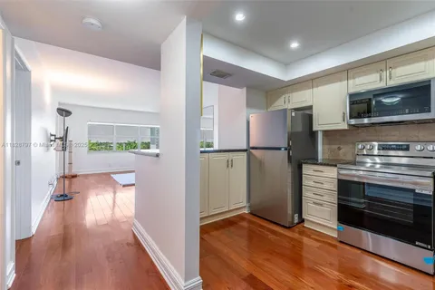 a kitchen with stainless steel appliances granite countertop a refrigerator and a stove top oven