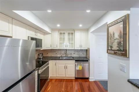 a kitchen with stainless steel appliances granite countertop a refrigerator sink and stove