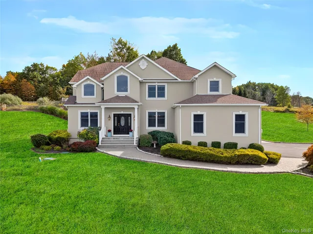 a front view of a house with garden and trees