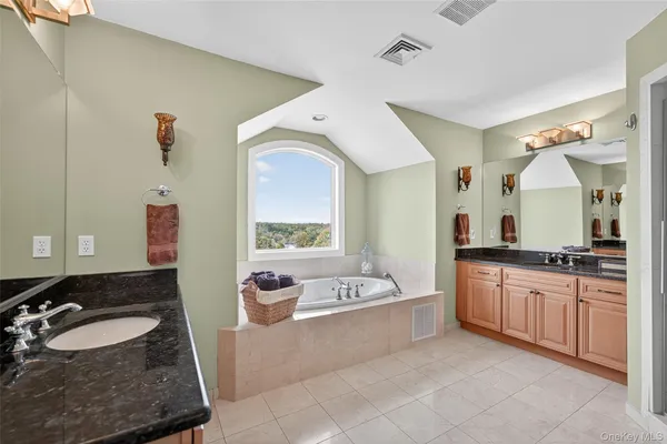 a spacious bathroom with a granite countertop tub sink and mirror