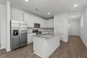 a large kitchen with a center island stainless steel appliances and cabinets