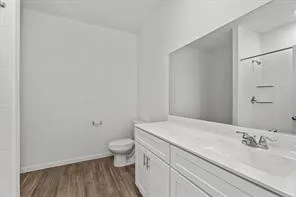 a bathroom with a granite countertop sink a toilet and a mirror