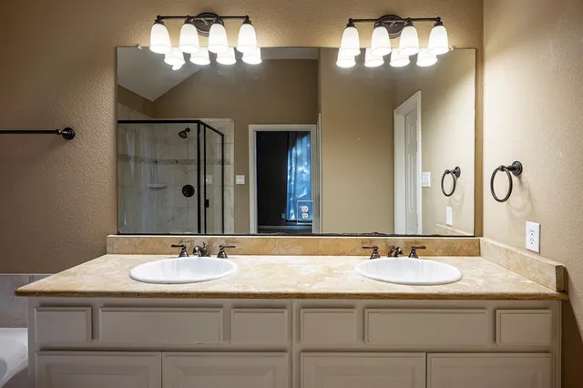 a bathroom with a shower and a sink a mirror