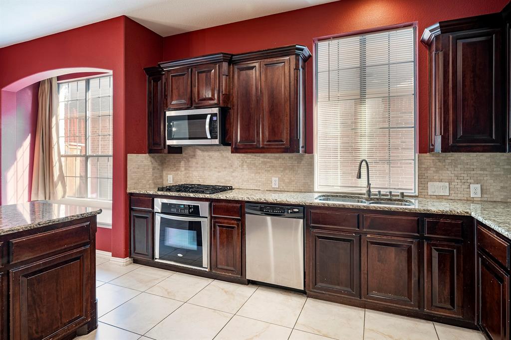 1138 Amy Drive Allen, TX 75013 - Photo 8 of 26 a kitchen with stainless steel appliances granite countertop a stove sink and cabinets