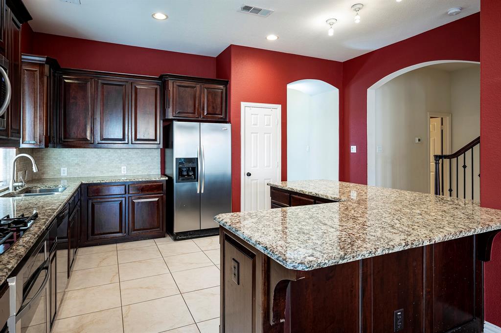 1138 Amy Drive Allen, TX 75013 - Photo 9 of 26 a kitchen with stainless steel appliances granite countertop a stove refrigerator and sink