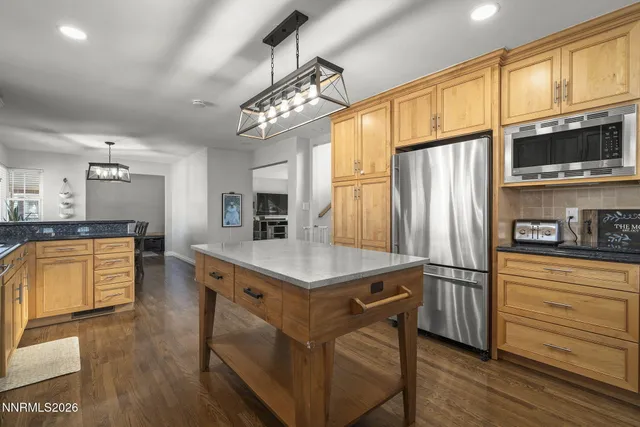 a kitchen with stainless steel appliances granite countertop a sink a stove and a refrigerator