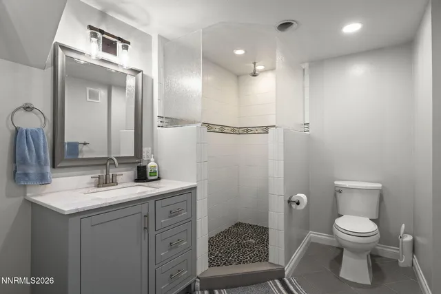 a bathroom with a granite countertop sink toilet and shower