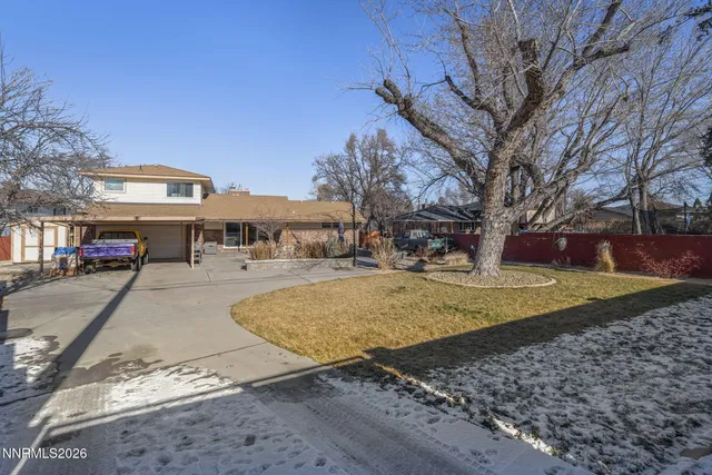 a view of a white house with a yard covered in snow