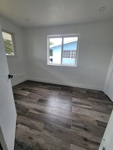 a view of a room with wooden floor and window