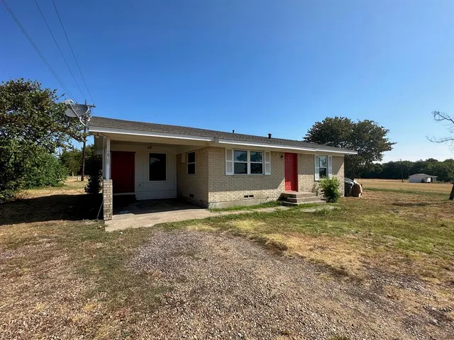 a view of a house with backyard and trees