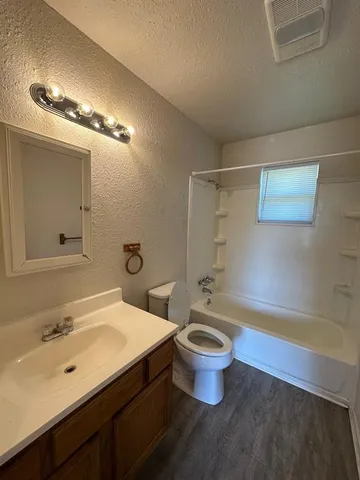 a bathroom with a sink a toilet a mirror and bathtub
