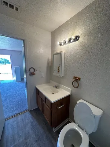 a bathroom with a toilet a sink and mirror