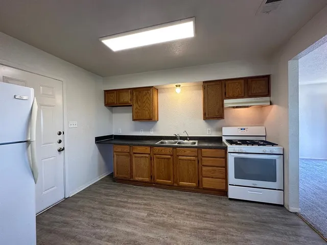a kitchen with stainless steel appliances granite countertop a stove a sink and a refrigerator