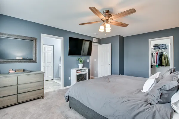 a bedroom with a bed and a flat tv screen on dresser