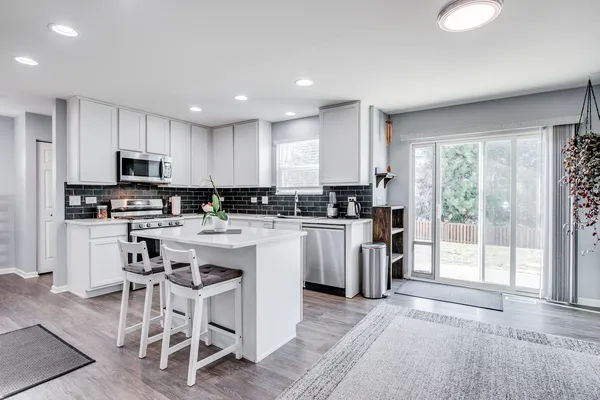 a kitchen with white cabinets and appliances