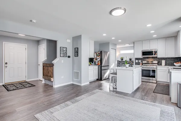 a kitchen with white cabinets and refrigerator
