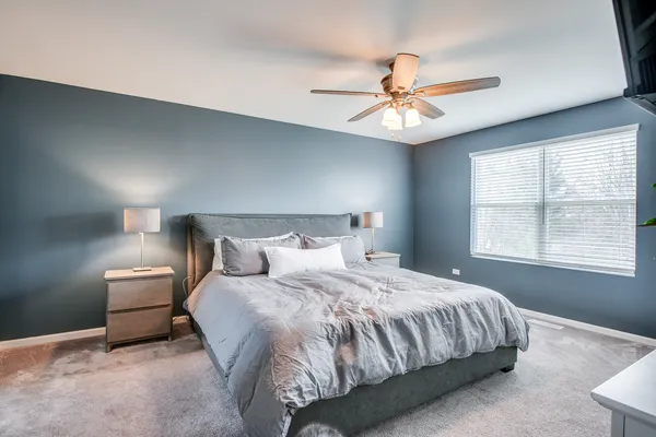 a bedroom with a large bed a flat tv screen and dresser