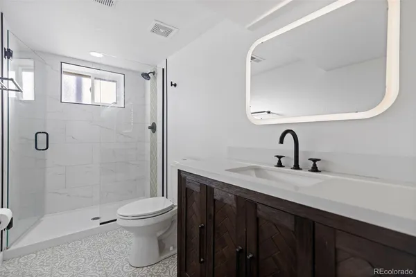 a bathroom with a double vanity sink toilet and shower