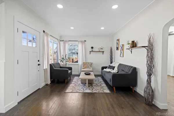 a living room with furniture and a wooden floor