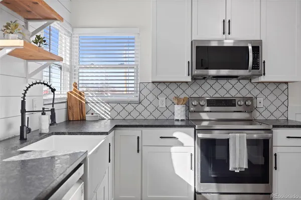 a kitchen with stainless steel appliances granite countertop a sink and a microwave