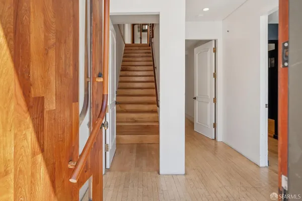 a view of a hallway with wooden floor and staircase