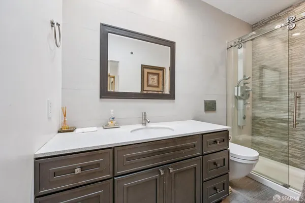 a bathroom with a sink a toilet and shower