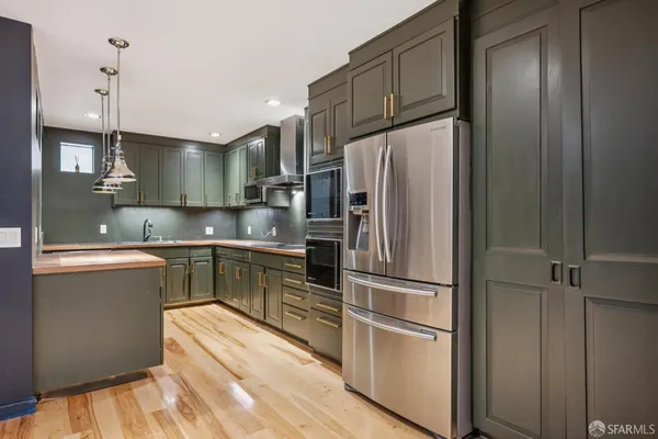 a kitchen with stainless steel appliances granite countertop a refrigerator and a sink