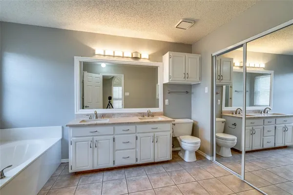 a spacious bathroom with a granite countertop sink a toilet and a shower