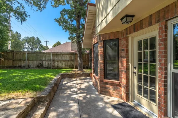 a view of backyard with wooden fence and large trees