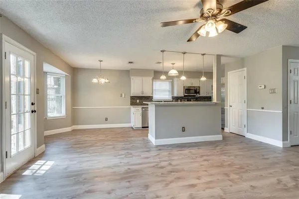 a kitchen with granite countertop a sink a counter space appliances and cabinets