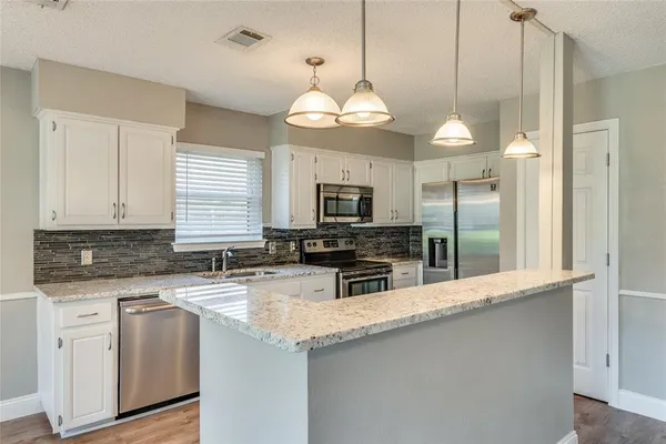 a view of a kitchen counter space a sink and appliances