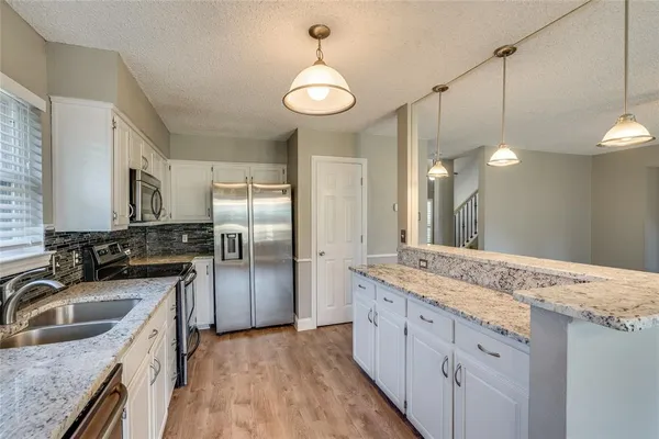 a kitchen with a sink stove and refrigerator