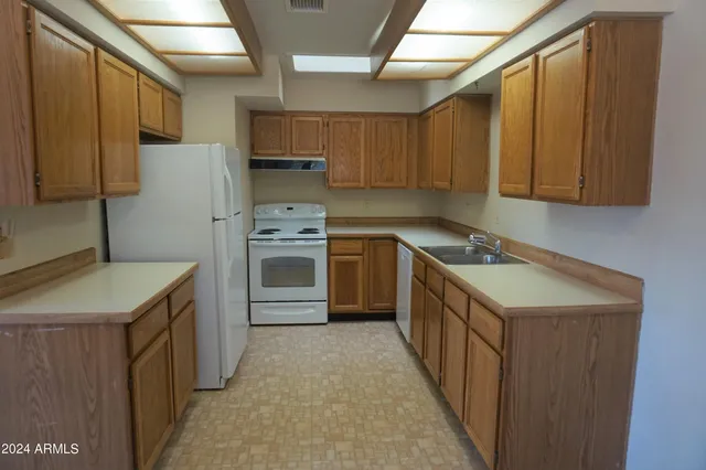 a kitchen with a sink stove top oven and refrigerator