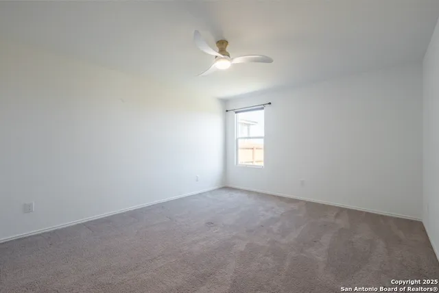 an empty room with a window and a ceiling fan