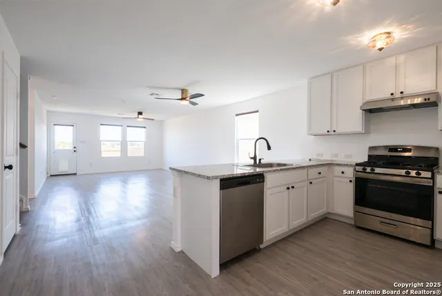 a kitchen with granite countertop a stove and a sink