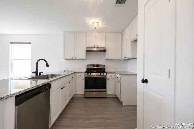 a kitchen with a sink stove and cabinets