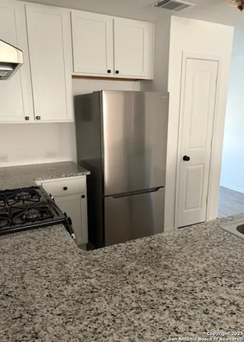 a kitchen with a refrigerator and cabinets